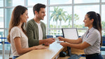 A smiling couple showing their driver's licenses at a car hire counter in the Orlando airport