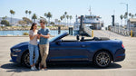 White car rental parked on the deck of a passenger ferry crossing a bay in California