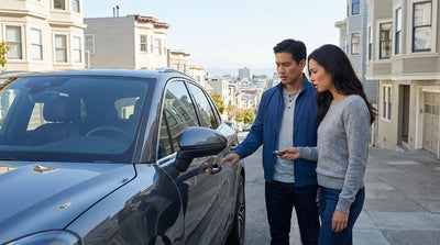 A modern car hire parked on a steep street in San Francisco with iconic Victorian houses in the background