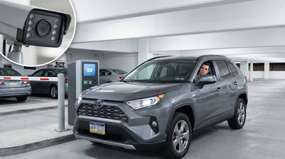 A modern car rental stopped at a car park exit barrier with an ANPR camera overhead in Pennsylvania