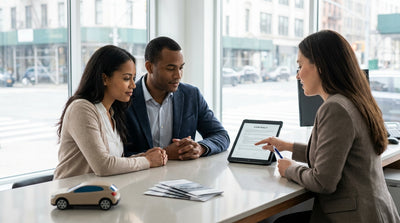 A person's hands on the steering wheel of a car rental with a view of busy New York City traffic through the windshield