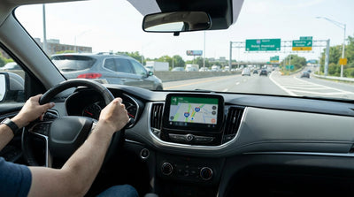 A white sedan car hire driving on a highway with the New York City skyline in the background
