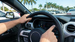Close-up of a driver checking the dashboard fuel gauge inside a car rental in Miami