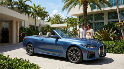 A blue BMW M4 car rental parked on a sunny street in Miami with palm trees and art deco buildings
