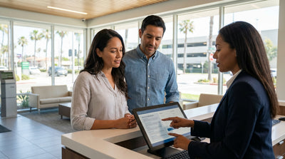 A person driving their car hire on an open road in the United States with mountains in the background