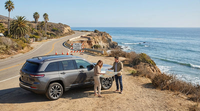 A car hire navigates the winding Highway 1 with dramatic views of the rugged California coastline and Pacific Ocean