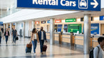 Traveler with luggage standing at a car rental counter inside Philadelphia Airport in Pennsylvania