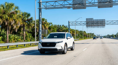 A modern car hire drives across a long, sunny bridge spanning the blue ocean in the Florida Keys