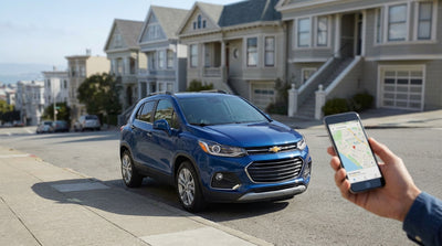 A small red car rental parked on a steep, iconic hill in San Francisco with Victorian houses lining the street