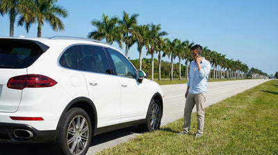 A car hire pulled over on the shoulder of a sunny highway in Florida with palm trees in the background