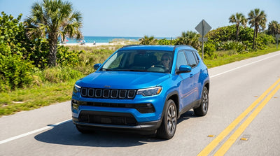 A convertible car hire driving down a sun-drenched road lined with palm trees near Orlando