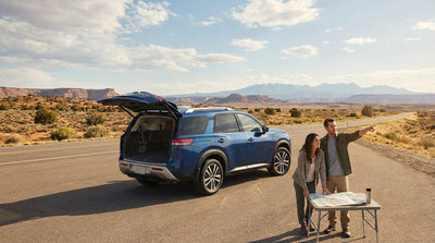 A silver car hire driving down a long highway through the vast desert landscape of West Texas
