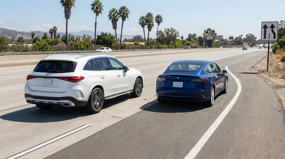 Traffic and a white car rental merging on a sunny California highway where a lane is closed with orange cones