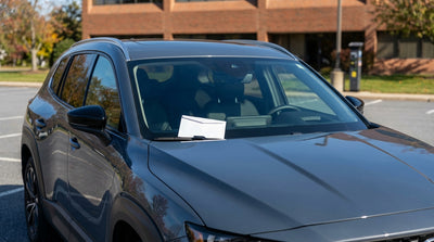 A parking charge notice on the windshield of a car rental vehicle in a parking lot in Pennsylvania