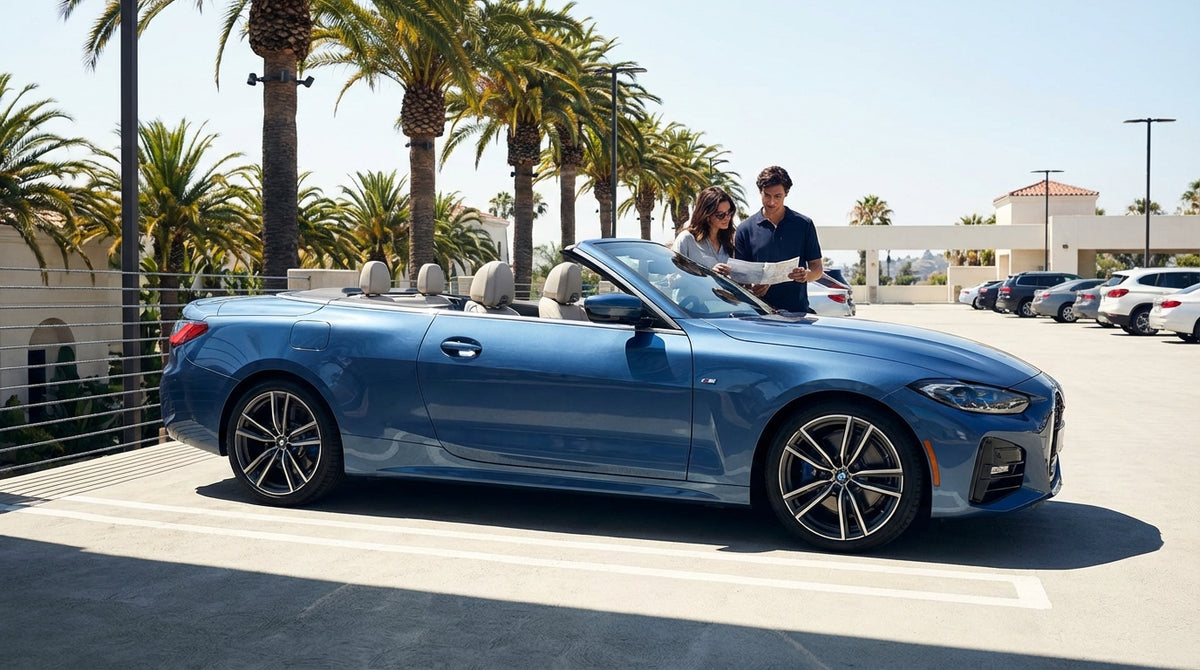 A convertible car rental driving on a scenic highway along the sunny California coast