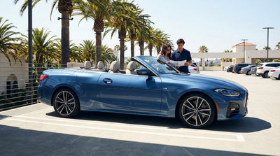 A convertible car rental driving on a scenic highway along the sunny California coast