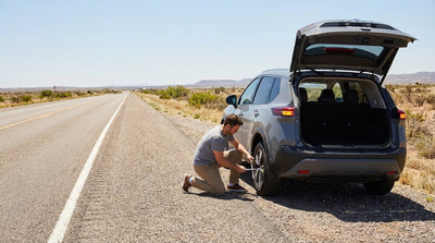 A car rental with a flat tyre pulled over on the shoulder of a wide motorway in Texas