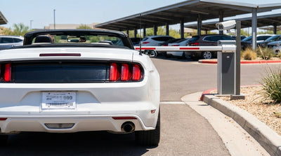 A car hire with a temporary Texas paper license plate at a car park entrance barrier