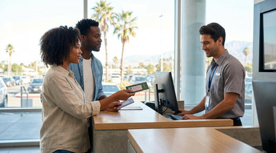 A red convertible car hire driving along a sunny, scenic coastal highway in California