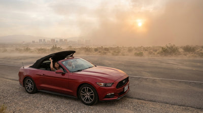 A convertible car rental on a desert road outside Las Vegas as a massive, dark dust storm approaches on the horizon