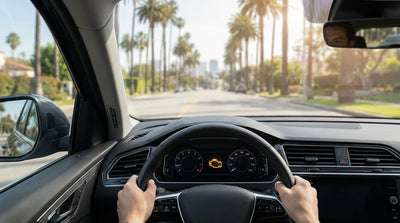 A car rental dashboard with a check-engine light on while driving through the streets of Los Angeles