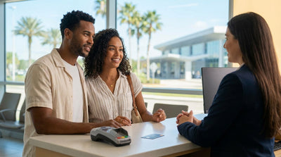 A person uses a debit card at a car rental counter in Orlando with car keys resting on the desk