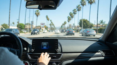 A driver's hand on the illuminated Auto Hold button on the center console of a Los Angeles car hire