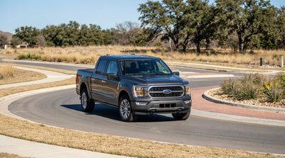 A sports car rental skidding on a roundabout on a sunny day in a suburban Texas neighborhood