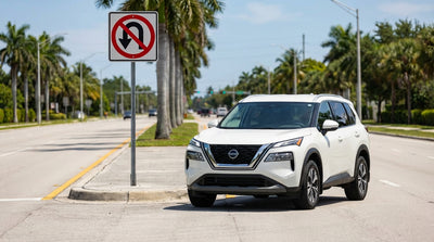 A modern car rental driving on a multi-lane road with a grassy median under the bright Florida sun