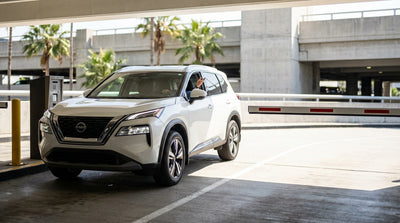 A silver car hire vehicle stopped at a closed parking exit barrier in an Orlando airport garage