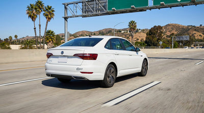 A car hire driving in the express lane on a sunny multi-lane freeway in Los Angeles