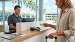 Customer handing a credit card to an agent at a car rental counter in Miami