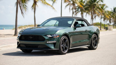 A convertible car hire driving along a sunny coastal highway with palm trees in Florida