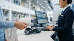 A customer hands a credit card to an agent at a car hire counter in a New York airport terminal