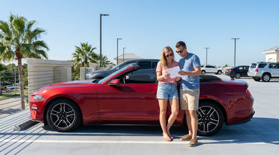 A red convertible car hire driving down a scenic coastal highway lined with palm trees in sunny Florida