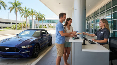 A red convertible car hire driving on a sunny coastal road with palm trees in Florida