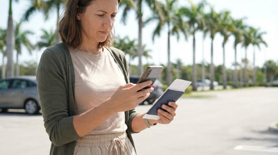 A white car rental driving across a long bridge over turquoise water on a sunny day in the Florida Keys