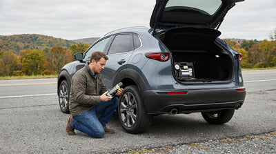 Driver using a tyre sealant kit on a Pennsylvania car hire parked on a scenic forest road