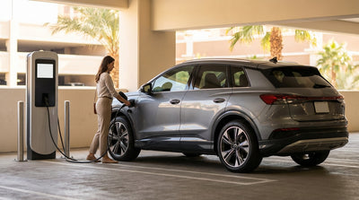 A white electric car hire driving down the Las Vegas Strip at dusk surrounded by glowing neon casino lights