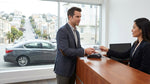 Customer giving a credit card to a clerk at a San Francisco car rental desk