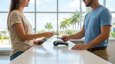 A red convertible car hire driving down a sunny road lined with palm trees in Florida