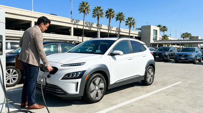 A white electric car from a car hire service plugged into a charging station in sunny Orlando