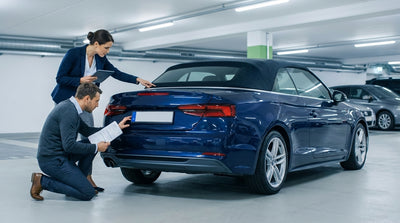 A driver comparing a contract to the license plate of their car rental on a New York street