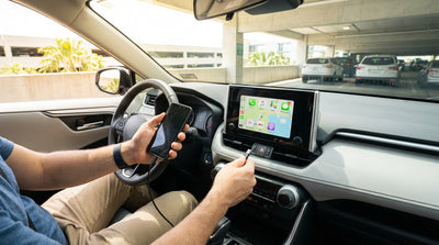 A driver connecting a smartphone to the dashboard of a car rental to use Android Auto in Orlando