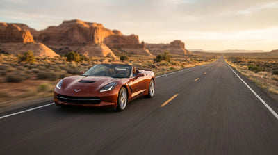 A lone car hire vehicle driving down a long, straight desert highway in the American Southwest