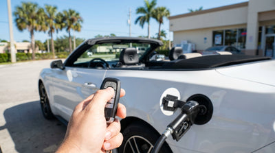 A person refuelling their modern car rental at a sunny gas station with palm trees in Florida