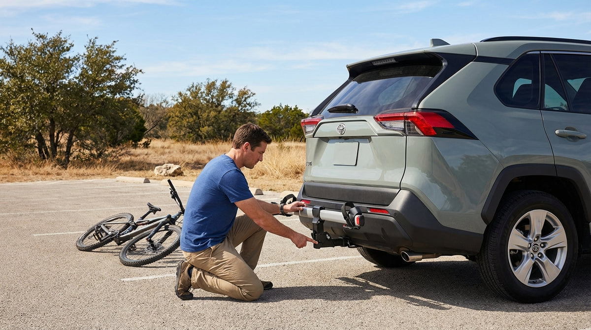 A cyclist mounts a mountain bike onto a rack on their car rental in a Texas state park