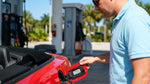 Close up of a fuel nozzle being inserted into a white car rental in Florida