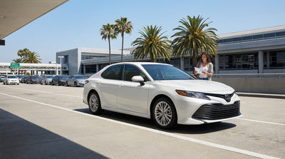 A customer receives keys for their car hire from an agent at a service desk in Los Angeles