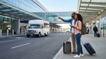 A white car rental shuttle bus waits for passengers outside a terminal at LaGuardia Airport in New York